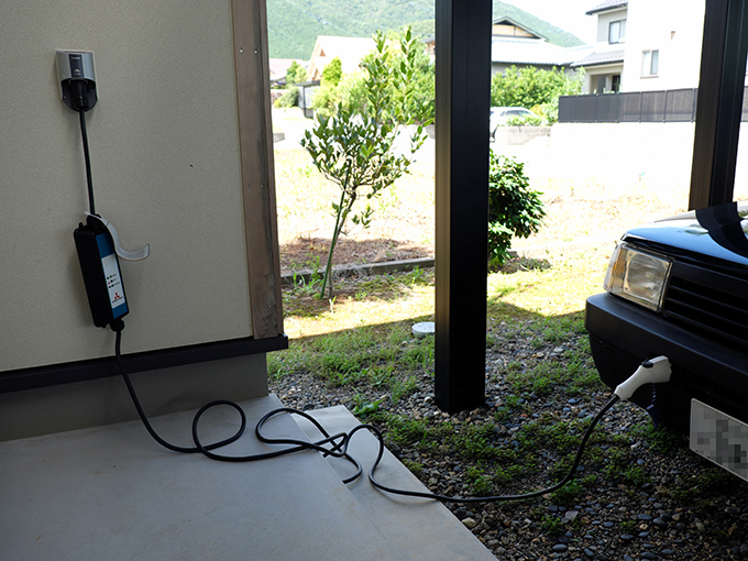 ▲新潟にある自宅の玄関には200Vの電源を用意。東京の充電器のない賃貸マンションでもやっていけるけれど、帰宅してこうやってつないでおけば翌朝は満タンだから、やっぱりラクだ